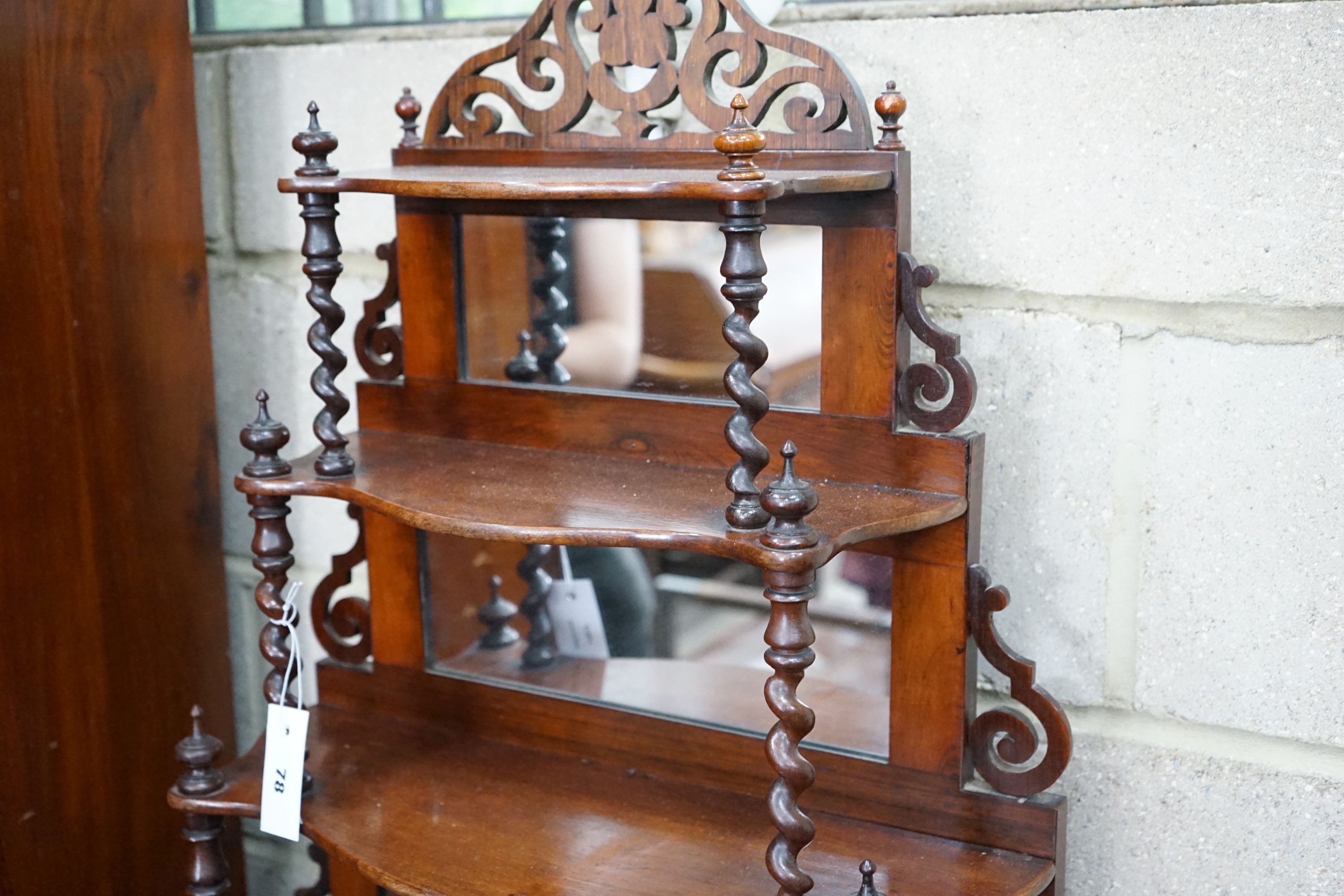 A late Victorian rosewood serpentine front six tier whatnot with mirror and barley twist support to shelves